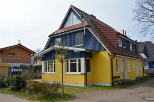 普雷罗Hagens Hus的黄色和蓝色的房子,屋顶为棕色