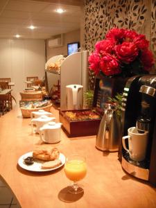 图尔商务旅行及旅游达芬奇酒店的一个带咖啡壶的柜台和一杯橙汁