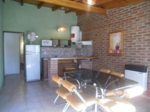 维拉卡洛斯帕兹Cabañas Tio Willy的厨房配有桌椅和砖墙