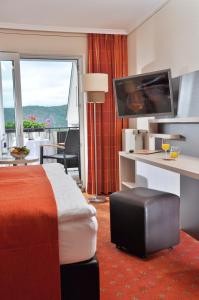 博帕德兰德卡斯福里特尔酒店的酒店客房配有一张床和一张书桌及一台电视