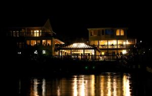 巴克斯顿The Inn on Pamlico Sound的夜间在水体旁的一座有照明的建筑