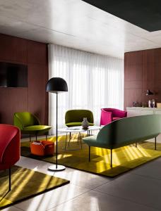 戛纳戛纳中心奥克酒店的客厅配有五颜六色的椅子和桌子