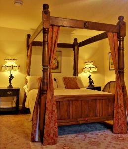 MallwydThe Firecat Country House Guesthouse的一间卧室配有一张带两盏灯的天蓬床。