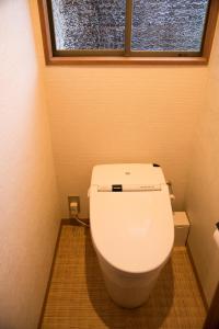 伊东伊东緑涌日式旅馆的浴室设有白色卫生间和窗户