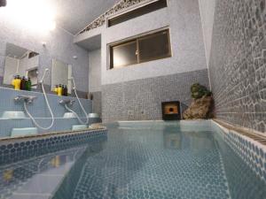 伊势市日出旅馆的浴室设有带淋浴和水槽的游泳池