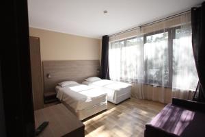 布拉索夫城市公寓式酒店的酒店客房设有两张床和大窗户。