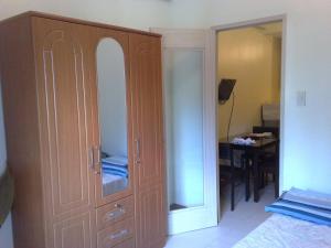 马尼拉爱丽舍城堡公寓式酒店的一间卧室配有带镜子的大型木制橱柜