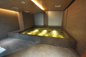 芝卡朗GTV公寓式酒店的浴室配有装满金色水的浴缸。