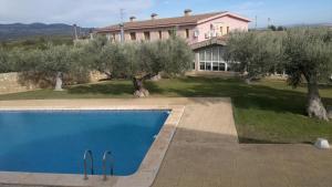 Vall dʼAlba勒尔米塔卡萨里波酒店的一座带游泳池和橄榄树的房屋
