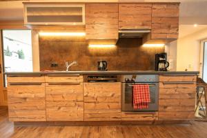 图克斯Chalet Alpinhome的厨房配有木制橱柜和炉灶。