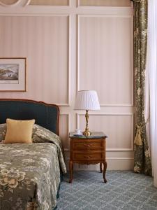 维也纳Grand Hotel Wien的一间卧室配有一张床和一张带台灯的桌子