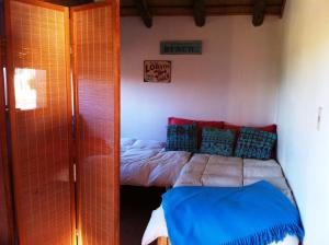 德尔迪阿布罗角艾伦德诺斯度假屋的一间卧室配有蓝色和红色枕头的床