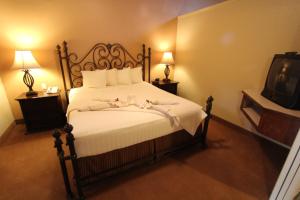 塞多纳Villas at Poco Diablo, a VRI resort的一间卧室配有一张带白色床单的床和一台电视。