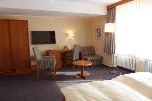 黑尔福德汉莎酒店的酒店客房配有一张床、一张书桌和一台电视。