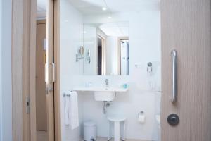 佩尼斯科拉阿奎兰蒂公寓式酒店的白色的浴室设有水槽和镜子