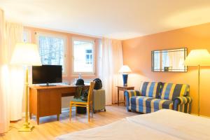 布兰肯堡维多利亚·路易丝别墅酒店的酒店客房配有一张床、一张桌子和一把椅子。
