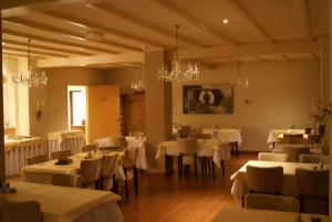 斯欣奥普赫尔贝梅尔曼斯酒店的用餐室配有白色桌椅和吊灯。