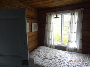 萨洛Vuohensaari Camping Ahtela's cottage的一间卧室设有一张床和一个大窗户