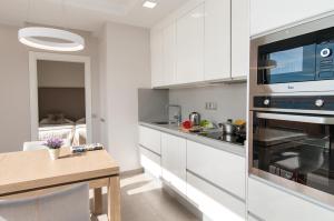 大加那利岛拉斯帕尔马斯Apartment Las Canteras Nautilus 8D的厨房配有白色橱柜和炉灶烤箱。