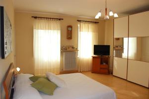 PontesturaCascina Fietta - Wine Dreams Apartments的卧室配有白色的床和电视。