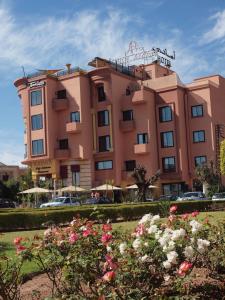马拉喀什Amani Hotel Suites & Spa的前面有鲜花的粉红色建筑