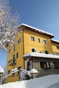 法纳诺Hotel Gabriella的前面有雪的黄色建筑