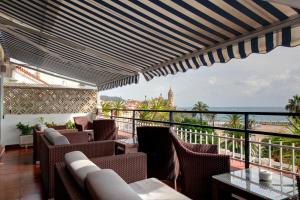 锡切斯普拉特雅道尔酒店的阳台配有椅子,享有海景。