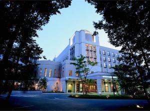 水户水户广场酒店(Mito Plaza Hotel)的一座白色的大建筑,灯火通明