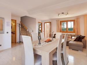 阿尔库迪亚港Casa Paraiso de Alcudia的一间带木桌和白色椅子的用餐室
