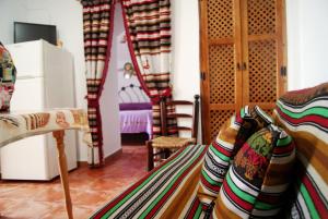 瓜迪克斯Cuevas de María的客房设有沙发、桌子和冰箱。
