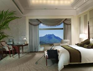 东莞东莞长安国际酒店的一间卧室配有一张床、一张书桌和一个窗户。