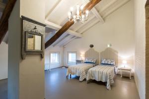 BorzanoVerdenoce Agriturismo B&B的一间卧室配有两张床和吊灯。