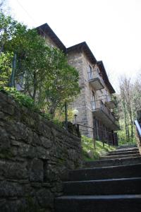 贝加莫伊格里住宿加早餐旅馆的一座石头建筑,在一座建筑前有楼梯