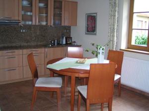 济维科夫斯科波德拉迪Apartment 53 Zvíkovské Podhradí的厨房配有木桌、椅子、桌子和椅子