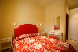 斯科派洛斯Porto Skopelos Villas的一间卧室配有红色的床和红色床头板