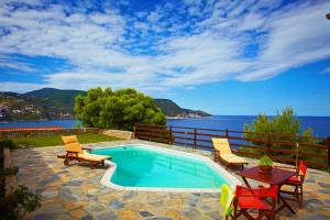 斯科派洛斯Porto Skopelos Villas的一个带桌椅的海洋游泳池