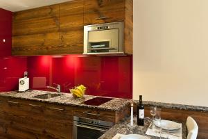 采尔马特Studio Castor Zermatt的厨房设有红色的墙壁和带水槽的台面