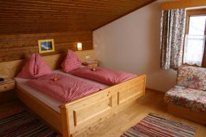阿尔滕马克特蓬高Berggasthof-Ferienbauernhof Habersatt的一张带红色枕头的木床