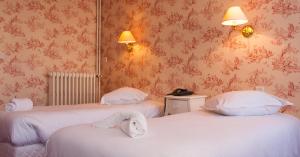 滨海图维列诺曼底梅森酒店的一间设有两张床铺和毛巾的房间