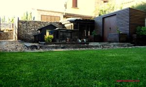 BielCasa Rural Las Lezas的一座带建筑和绿色草坪的庭院