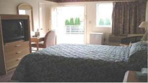Locust ValleyTides Inn at Stehli Beach的酒店客房,配有床和电视