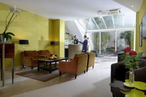 巴黎兰花酒店的客厅设有黄色的墙壁和桌椅