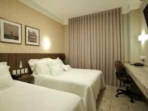 亚美利加纳美洲至尊诺酒店的酒店客房配有两张床和一张书桌