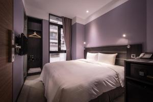 台北艺宿商旅 - 台北 (宁夏馆)的卧室配有一张白色大床和紫色墙壁