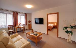 Alfrédov阿尔弗莱多福高尔夫康体度假酒店的带沙发的客厅和带沙发床的房间