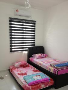 新山舒适度假屋@武吉英达的带窗户的客房内设有两张单人床。