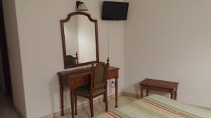 格罗韦Hotel Serantes的一间卧室配有一张带镜子和椅子的桌子
