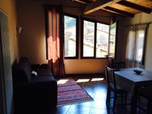 多尔切阿夸La Casetta的带沙发、桌子和窗户的客厅