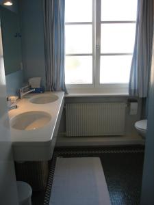巴塞尔The Garden Guesthouse的一间带两个盥洗盆和窗户的浴室