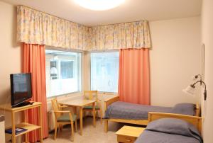 图尔库Meri-Karina的一间卧室配有两张床、一张桌子和一张桌子